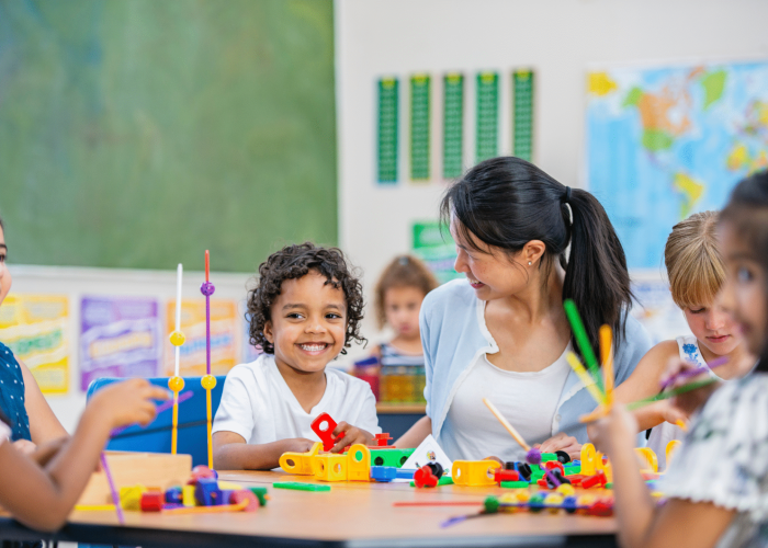 Smiling woman and children in a classroom setting